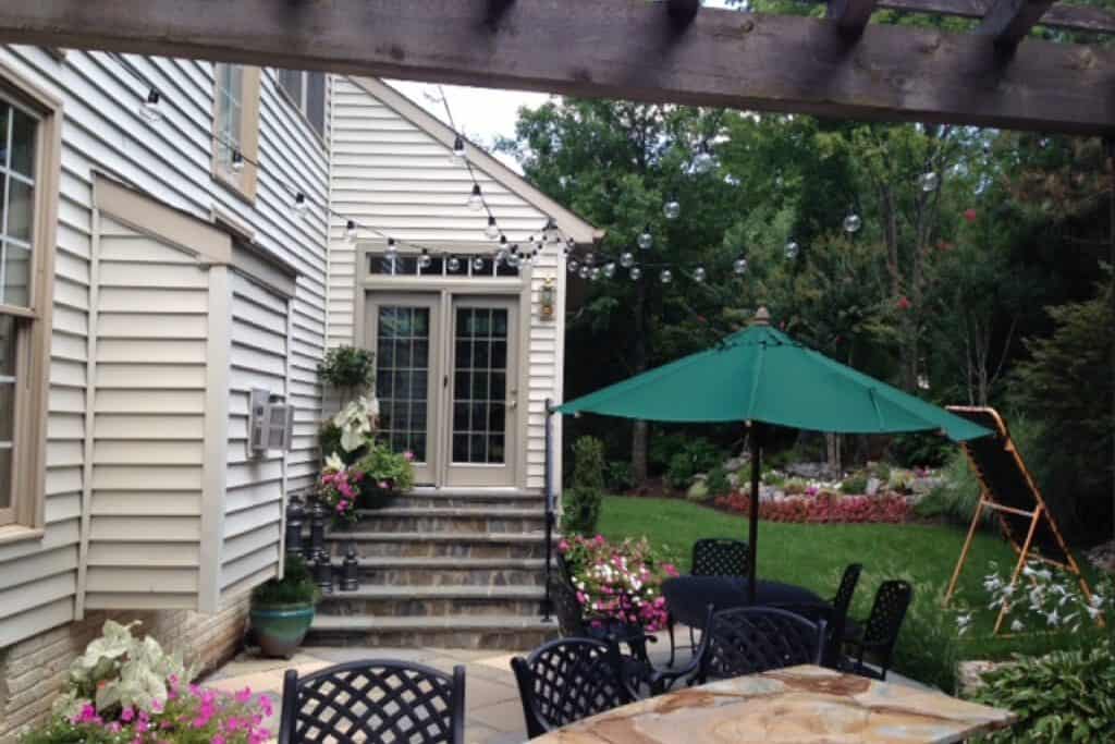 patio lighting hung in a backyard behind a house in the day time